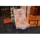 A gossip type chair, of low form, upholstered in cream and red floral fabric,