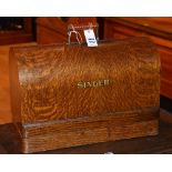 A vintage Singer sewing machine, in oak carry case,
