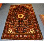 A Hamadan rug, the central flowerhead medallion over navy ground,