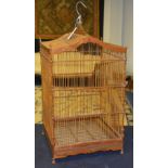 A vintage wooden birdcage, with turned wood structure, slide door and slide out base tray,