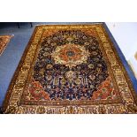 A Tabriz carpet, the central orange medallion over navy ground with allover foliate detail,