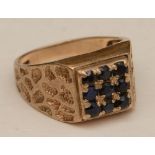 A 9ct gold and sapphire ring, the wide band set with nine round cut sapphires in square formation,