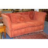 A modern two seater settee, upholstered in pale red floral velour,