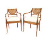 PAIR OF SHERATON REVIVAL OPEN ARMCHAIRS each with painted floral decoration, a cane back and seat,