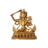 CHINESE QING PERIOD GILT BRONZE BUDDHA holding a sword in one hand, seated on a lotus cushion 22 cm.