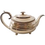 GEORGE III SILVER TEAPOT with a gadrooned rim surmounted by a gadrooned finial, furnished with a