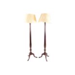 PAIR OF LARGE MAHOGANY STANDARD LAMPS each with a reeded stem raised on a scroll legged pod,