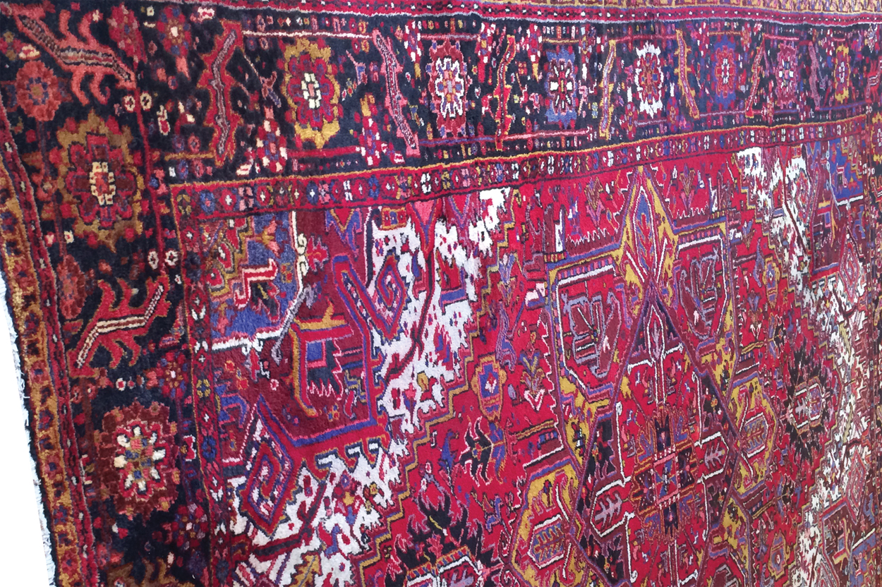 HANDWOVEN NORTHWEST PERSIAN CARPET on red ground with central medallion, navy border and ivory