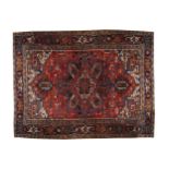 NORTHWEST PERSIAN HERIZ CARPET, CIRCA 1920 on red ground with ivory cartouches and blue border 256 x