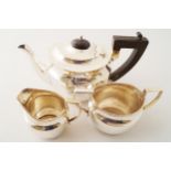 THREE-PIECE SILVER TEA SET each of oval form. Teapot with an ebony handle and lid. Birmingham