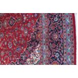 WEST PERSIAN KASHAN CARPET on red ground with blue border 412 x 297 cm. Worldwide shipping