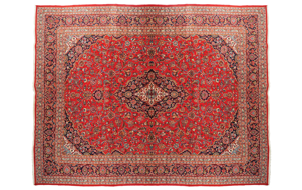 WEST PERSIAN KASHAN CARPET, CIRCA 1930 on red ground with central medallion and navy border 387 x