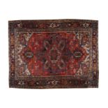 NORTHWEST PERSIAN HERIZ CARPET, CIRCA 1920 navy border, red ground, ivory spandrels 337 x 256 cm.