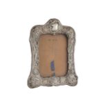 EDWARDIAN EMBOSSED SILVER PHOTO FRAME with leaf and flower decoration 20 x 13 cm.