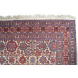 PERSIAN CARPET with an ivory field and overall flowerhead and palmette lattice 350 x 240 cm.