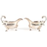 PAIR OF LONDON SILVER SAUCE BOATS, CIRCA 1750 each with a gadrooned and scroll handle, raised on