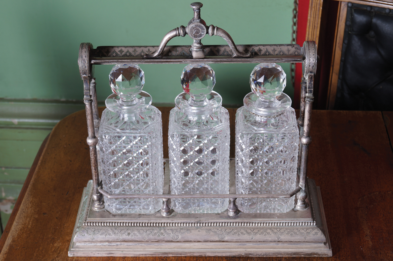 OLD SHEFFIELD SILVER PLATED TANTALUS with three crystal cut glass decanters and stoppers 35 cm.