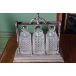 OLD SHEFFIELD SILVER PLATED TANTALUS with three crystal cut glass decanters and stoppers 35 cm.