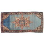 PERSIAN MOUD RUG shaded blue field with lobed medallion within a flower head border 246 x 116 cm.