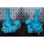 PAIR OF NINETEENTH-CENTURY POTTERY VASES each resting on an Oriental figure 14 cm. high (2)