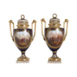 PAIR OF NINETEENTH-CENTURY DRESDEN PARCEL GILT AND PAINTED LIDDED URNS each with elongated scroll