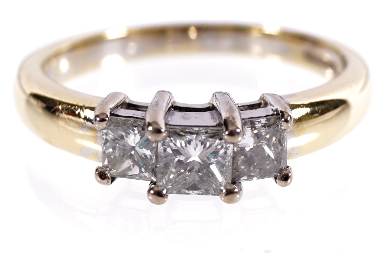 18 CT. YELLOW AND GOLD MOUNTED THREE STONE RING set with three princess cut diamonds weighing 1 ct.