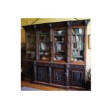 LARGE NINETEENTH-CENTURY CARVED OAK BREAKFRONT BOOKCASE the superstructure with a mask carved