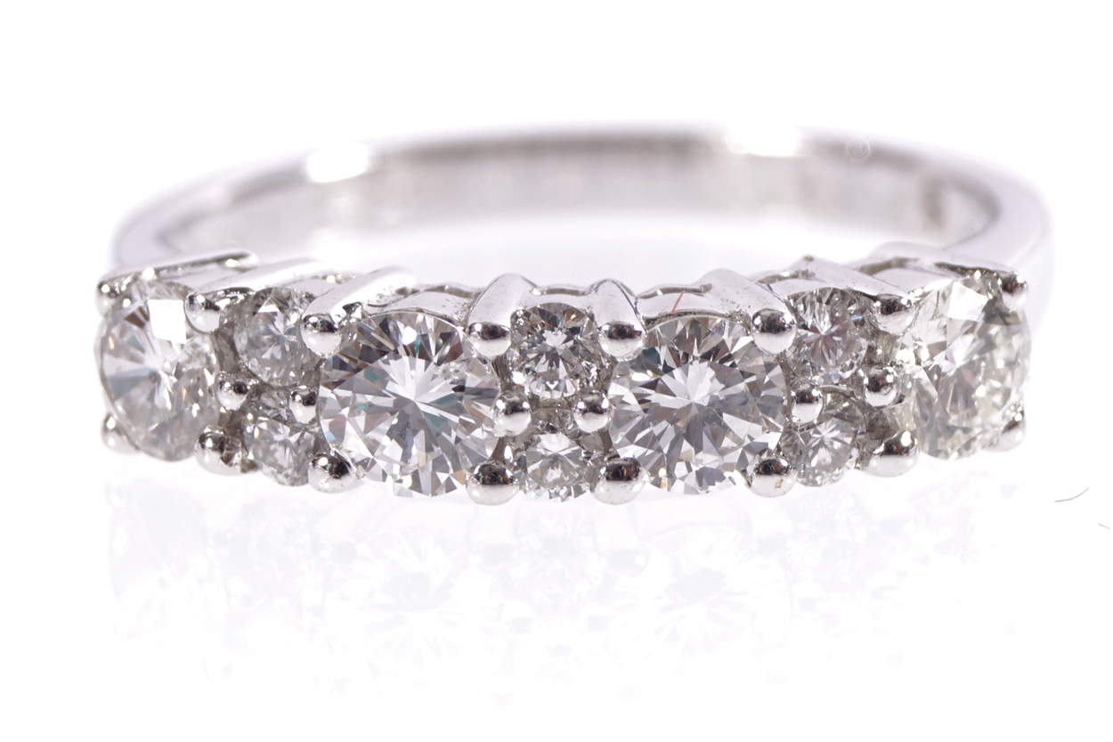 18 CT. WHITE GOLD MOUNTED HALF HOOP RING set with four large diamonds and six small brilliant cut