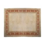 HANDWOVEN CARPETon plain ivory field, with red floral border and outer ivory guard345 x 271 cm.