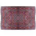 SOUTHEAST PERSIAN CARPETwith ivory and navy cartouches, and large red border257 x 348 cm.