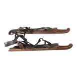 Paar Schlittschuhe 1890/1900, geformte Holzsohle mit integrierten Kufen, Lederriemen mit Messingösen