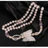 ROSENQUARZ HALSKETTEmit geschnittenem Schmetterling. L.90cmA ROSE QUARTZ NECKLACEwith cut butterfly,