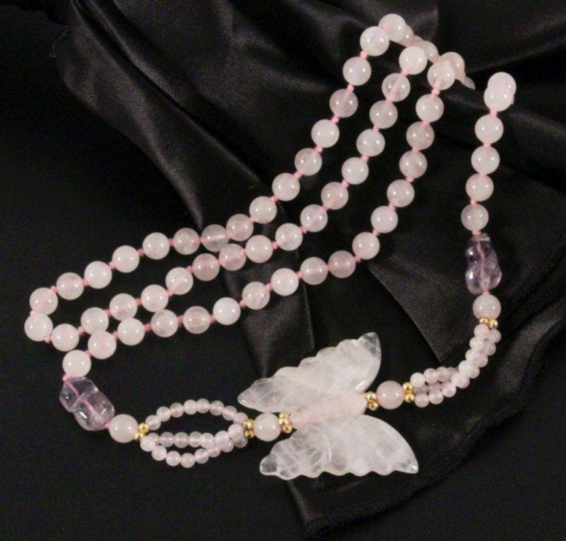 ROSENQUARZ HALSKETTEmit geschnittenem Schmetterling. L.90cmA ROSE QUARTZ NECKLACEwith cut butterfly,