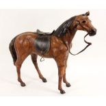 GESATTELTES REITPFERDLeder. L.52cm, H.43cm A SADDLED HORSELeather, 52cm long, 43cm high.