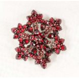 GRANATBROSCHE in Rosettenform. Vergoldet. D.3,5cm A GARNET BROOCH in rosette form. Gilt. 3.5cm