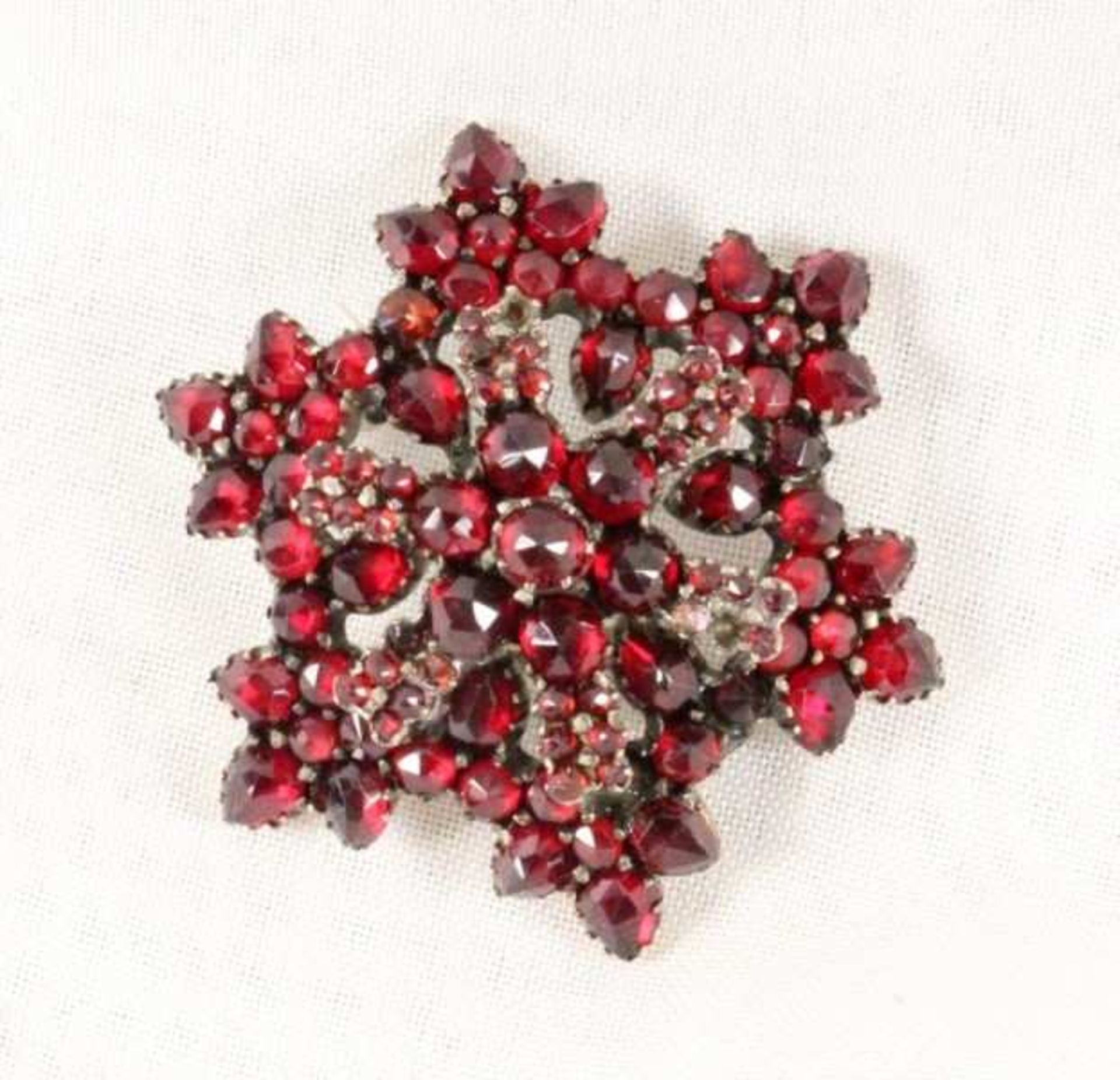 GRANATBROSCHE in Rosettenform. Vergoldet. D.3,5cm A GARNET BROOCH in rosette form. Gilt. 3.5cm