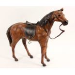 GESATTELTES REITPFERD Leder. L.52cm, H.43cm A SADDLED HORSE Leather, 52cm long, 43cm high.