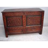 An 18th century oak carved mule chest, the hinged rectangular panel top above a carved foliate