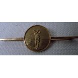 An 18ct gold golf medal mounted on a 18ct gold bar brooch, the circular medal with raised figure