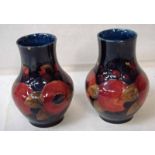 A pair of William Moorcroft Pomegranate pattern vases on a blue ground, with blue painted