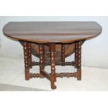 A large oak dining table with bold bulbous supports, joined by a stretcher, 138cm wide by 74cm high,