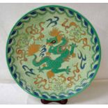 A Crown Ducal Charlotte Rhead dish decorated with a dragon on a green ground, signed by artist and