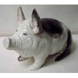 A Wemyss black and white pig, circa 1900, crouching on his haunches, incised Wemyss ware R H & S
