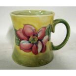 A William Moorcroft pottery mug of waisted cylindrical form, applied loop handle, tubeline decorated