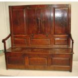 An unusual early 18th century oak settle/table with high three panelled back, the central panel