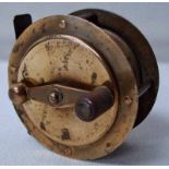 A brass fishing reel, stamped Milbro, with turned wood handle, takes WF3 size line, 7cm
