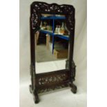 A 19th century Chinese table mirror, pierced hardwood frame and integral stand housing a shaped
