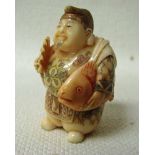 A Japanese ivory Netsuke, late 19th/early 20th century, a robed mythological character holding a fan