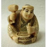 A Japanese ivory Netsuke, late 19th/early 20th century, a seated wood carver, signed to underside,