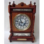 A 19th century walnut mantel clock, architectural style with Delft face, Arabic numerals, conforming